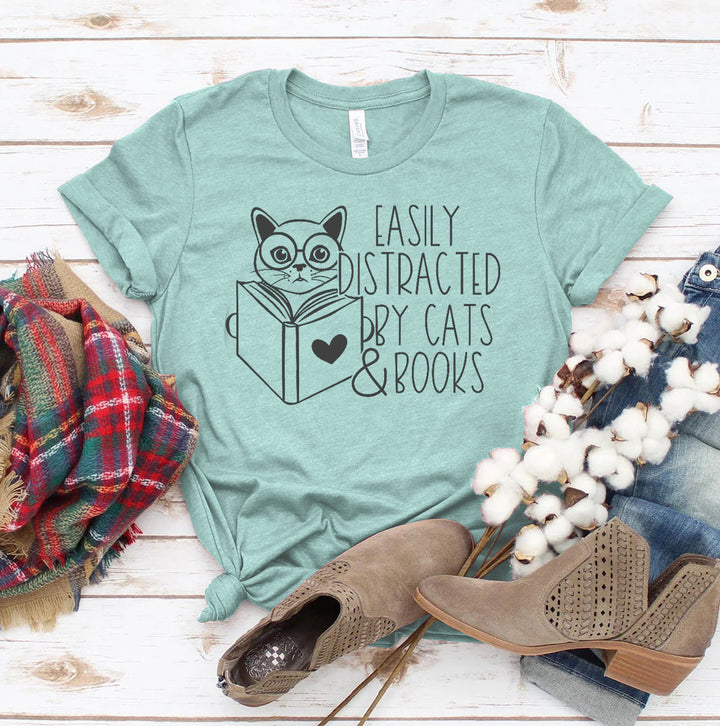 Green t-shirt with cat and book graphic and text &
