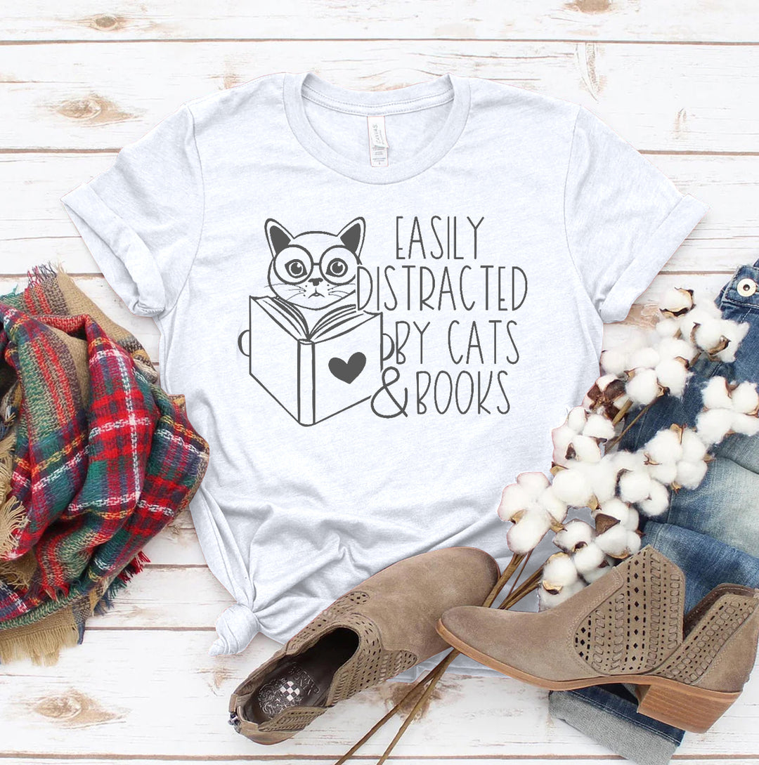 White t-shirt with a cat and book graphic and text &
