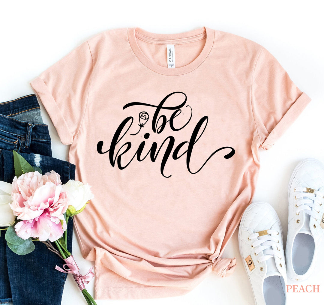 Be Kind T-shirt with elegant lettering, a reminder for positivity and compassion, styled with jeans and sneakers.