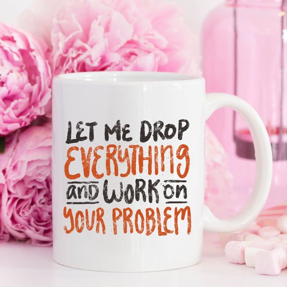 Coffee Mug with funny quote 'Let Me Drop Everything And Work On Your Problem' surrounded by pink flowers.